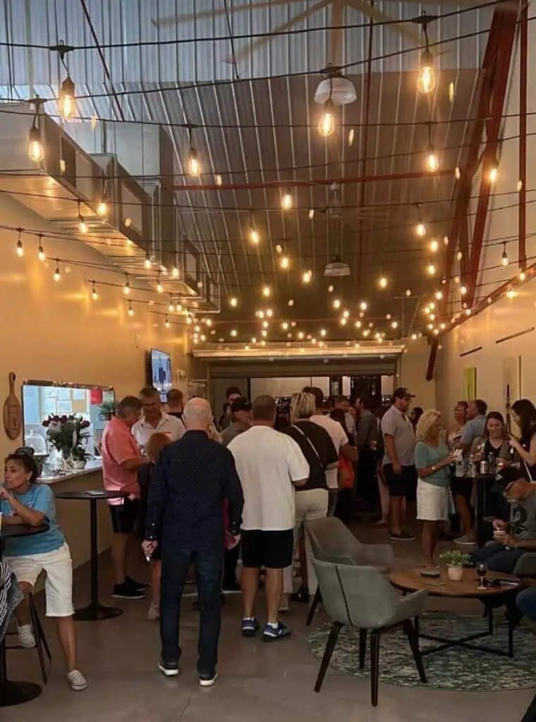 Guests mingling under string lights in the café at The Foodie Labs in St. Petersburg, FL